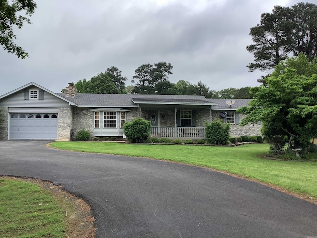 ranch-style house featuring a front yard, a garage, and covered porch