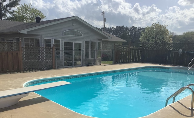 view of swimming pool featuring a diving board and a patio area