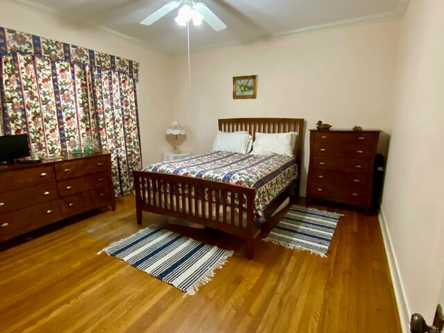 bedroom with ornamental molding, wood-type flooring, and ceiling fan