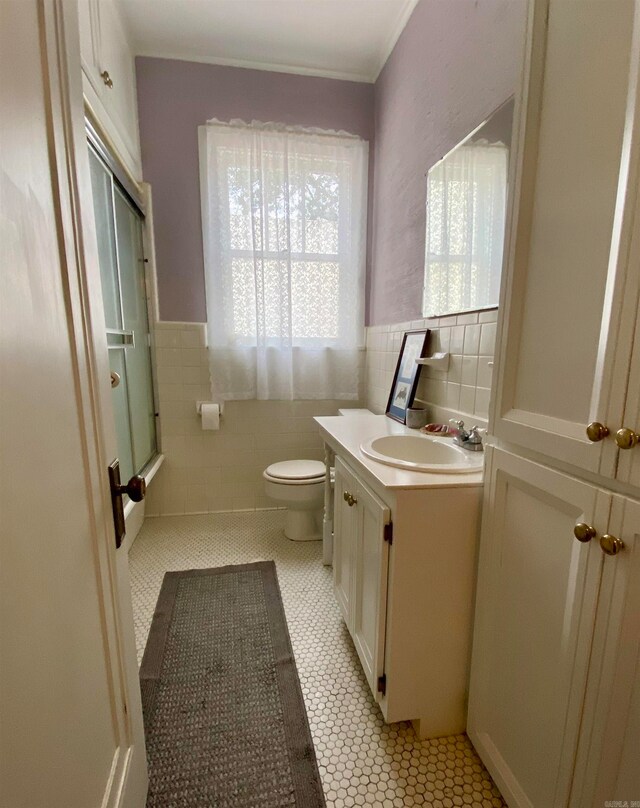 bathroom featuring tasteful backsplash, tile walls, tile floors, toilet, and vanity