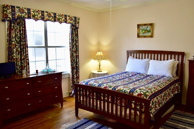 bedroom featuring crown molding and hardwood / wood-style flooring