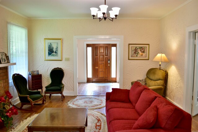 living room with crown molding, a chandelier, and wood-type flooring