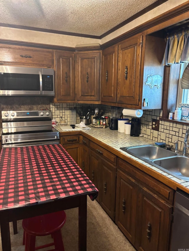 kitchen with dark brown cabinets, backsplash, stainless steel appliances, light carpet, and sink