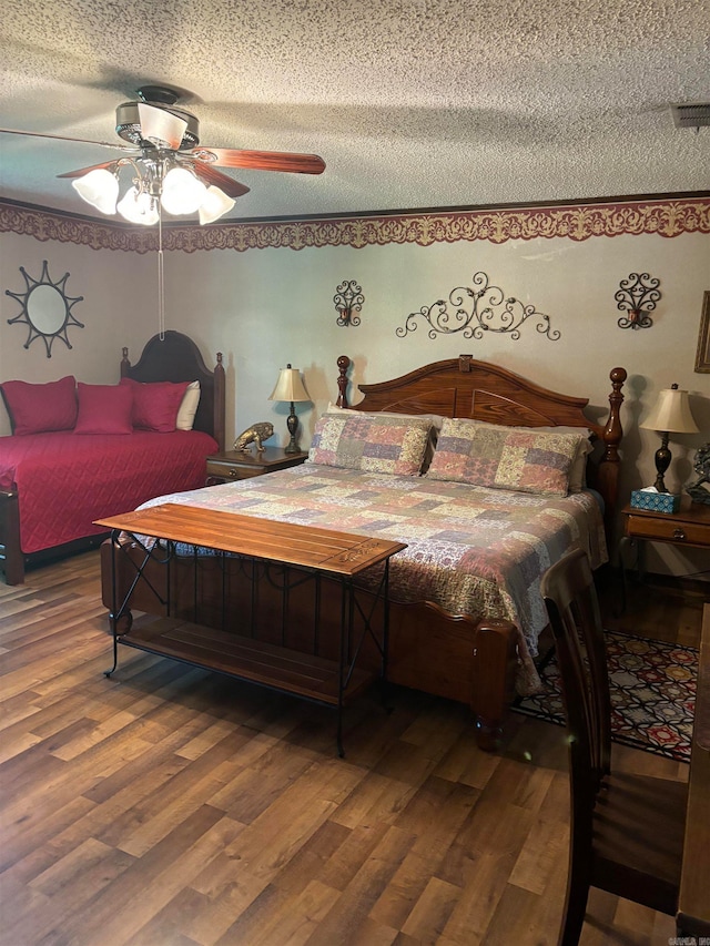 bedroom featuring hardwood / wood-style floors, ceiling fan, and a textured ceiling