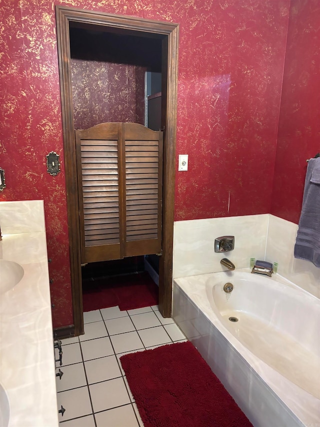 bathroom featuring tile floors, vanity, and a tub