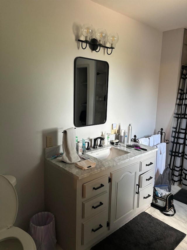 bathroom featuring toilet, tile floors, and vanity