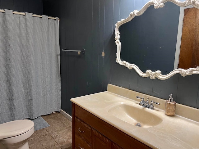 bathroom featuring tile floors, vanity with extensive cabinet space, and toilet