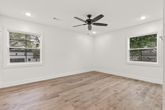 unfurnished room featuring light wood-type flooring, ceiling fan, and a wealth of natural light