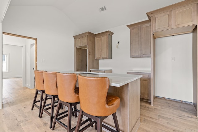 kitchen featuring light wood-type flooring and lofted ceiling