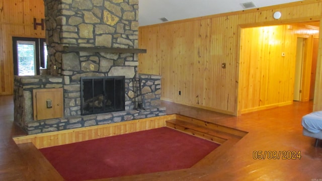 living room featuring wood walls and a fireplace