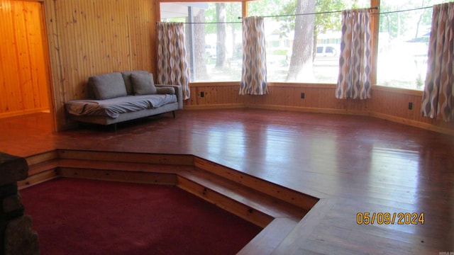 sitting room with hardwood / wood-style floors, wood walls, and a wealth of natural light