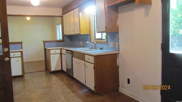 kitchen featuring tasteful backsplash, sink, light tile floors, and white cabinetry