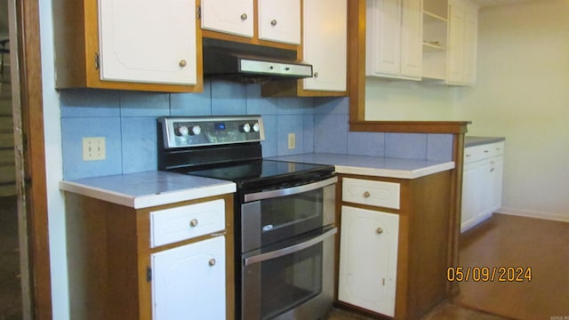 kitchen featuring tasteful backsplash, stainless steel range with electric cooktop, white cabinets, and fume extractor