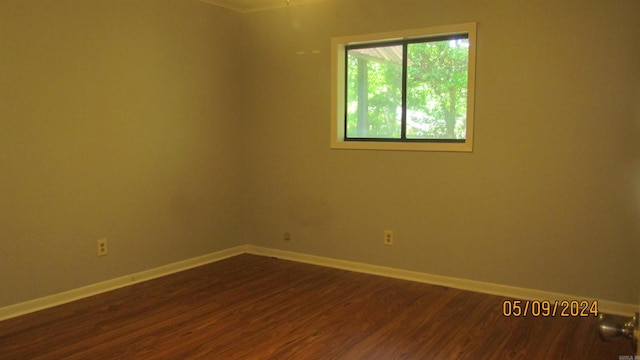 unfurnished room with dark wood-type flooring