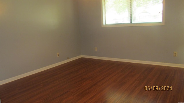 unfurnished room with dark hardwood / wood-style flooring