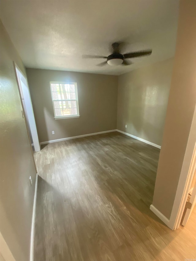 empty room featuring wood-type flooring and ceiling fan