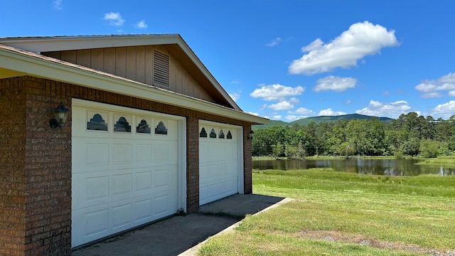 garage with a water and mountain view and a lawn