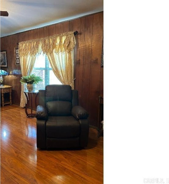 living area featuring hardwood / wood-style floors and wood walls