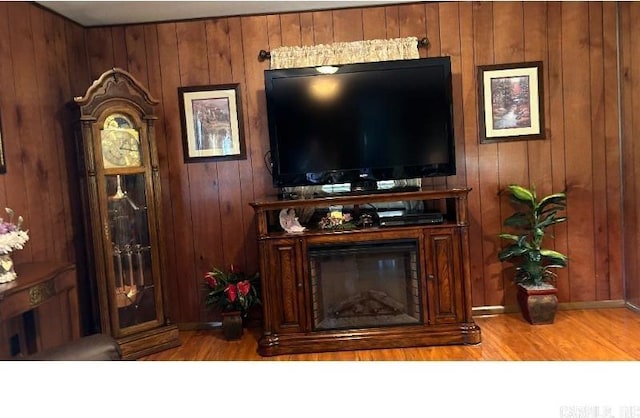 living room featuring light hardwood / wood-style flooring and wood walls