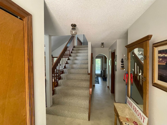 staircase with a textured ceiling