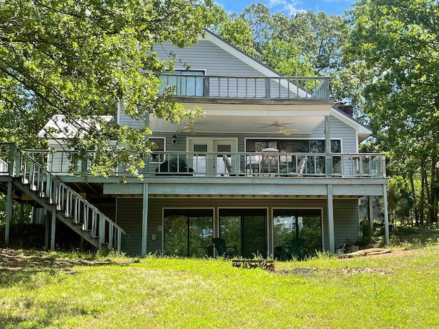 rear view of house with ceiling fan and a lawn