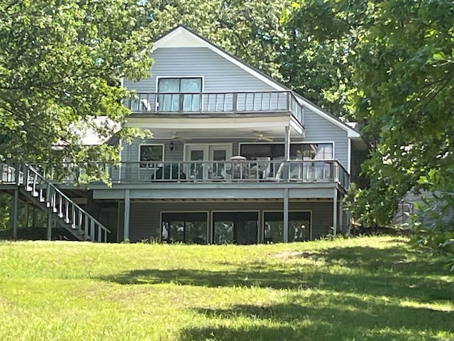 rear view of property featuring ceiling fan and a lawn