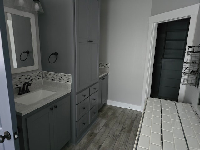 bathroom featuring vanity, hardwood / wood-style flooring, and tasteful backsplash