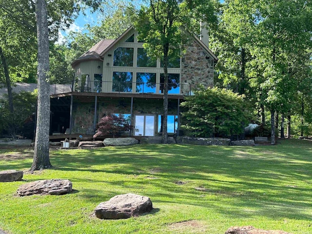 rear view of house with a deck and a lawn