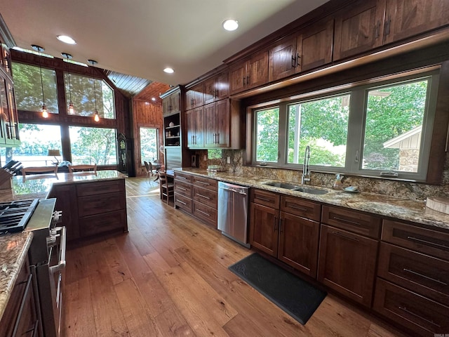 kitchen with wood-type flooring, appliances with stainless steel finishes, a healthy amount of sunlight, and sink