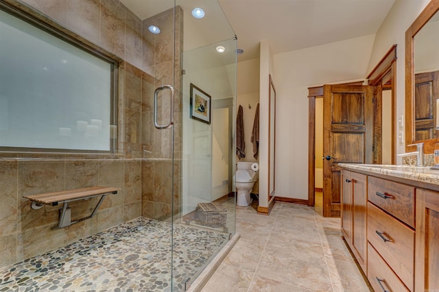 bathroom featuring walk in shower, large vanity, toilet, and tile flooring