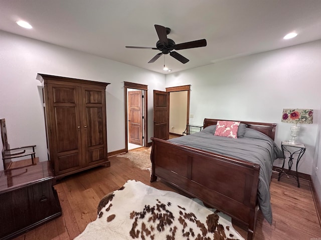bedroom with ceiling fan and hardwood / wood-style flooring