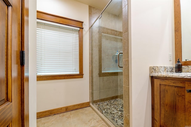 bathroom with walk in shower, vanity, and tile floors