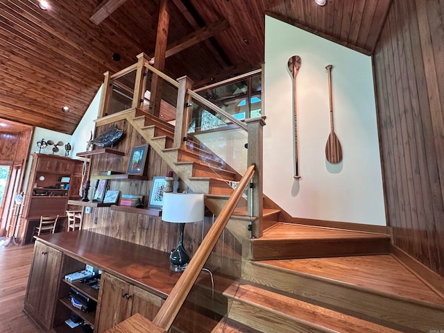 staircase featuring hardwood / wood-style floors, wooden ceiling, and wood walls