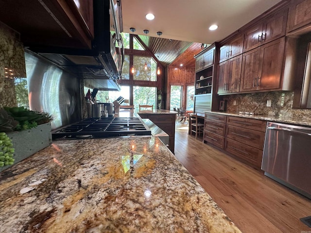 kitchen featuring tasteful backsplash, wood-type flooring, dishwasher, and stone countertops