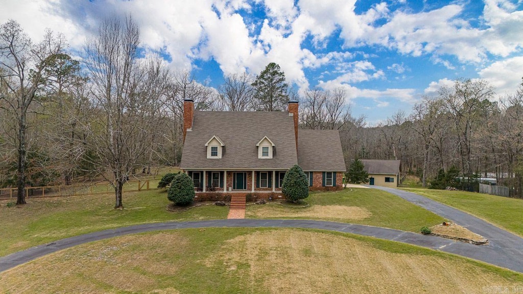 cape cod-style house featuring a front lawn