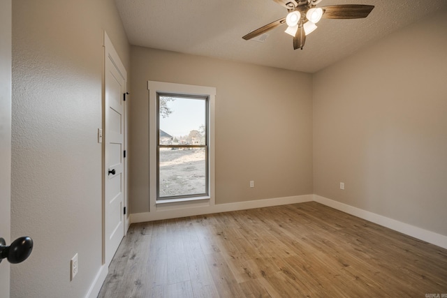 empty room featuring ceiling fan, a textured ceiling, and light wood-type flooring