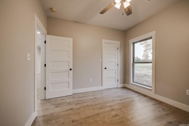 unfurnished bedroom with ceiling fan, light hardwood / wood-style flooring, and a textured ceiling