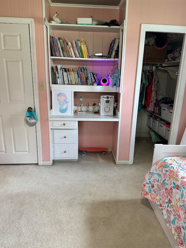 bedroom with built in desk, carpet flooring, and a closet