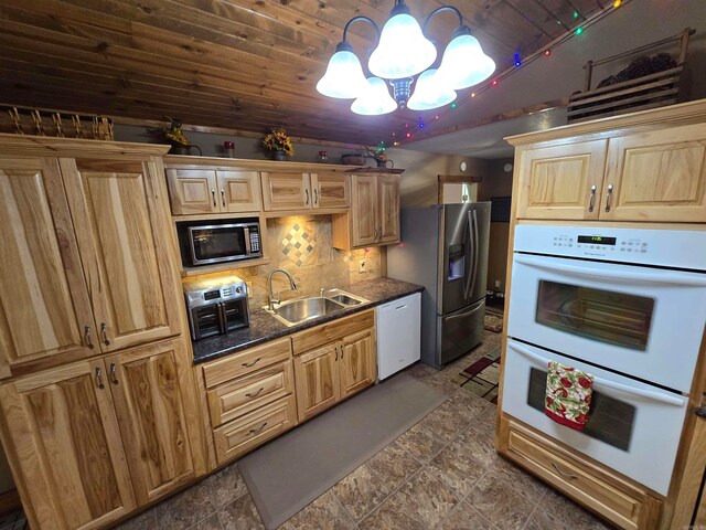 kitchen with stainless steel appliances, tasteful backsplash, wooden ceiling, dark tile flooring, and sink