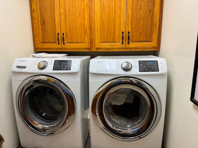 laundry area featuring washing machine and dryer and cabinets