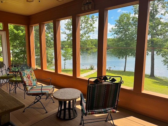 sunroom featuring a water view