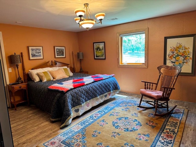 bedroom with a notable chandelier and hardwood / wood-style floors