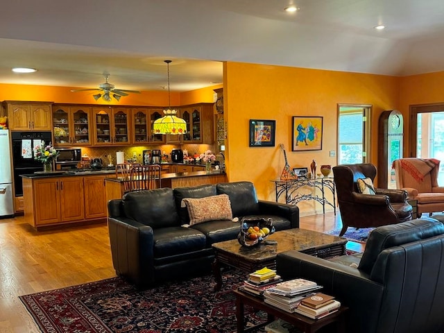 living room with light hardwood / wood-style floors and ceiling fan