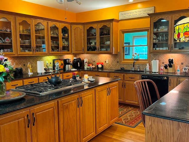 kitchen with tasteful backsplash, gas cooktop, dishwasher, and light hardwood / wood-style flooring