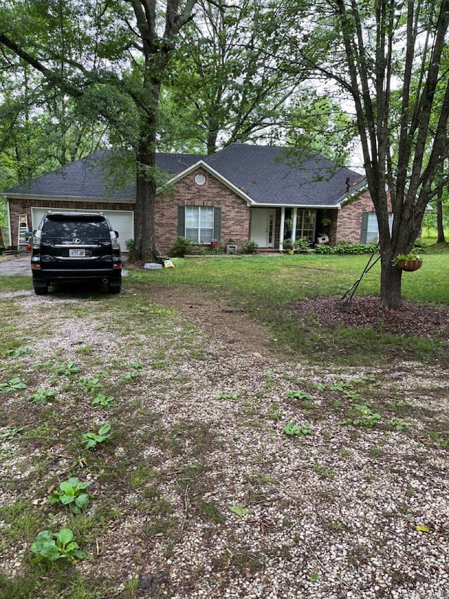 ranch-style house featuring a garage and a front yard