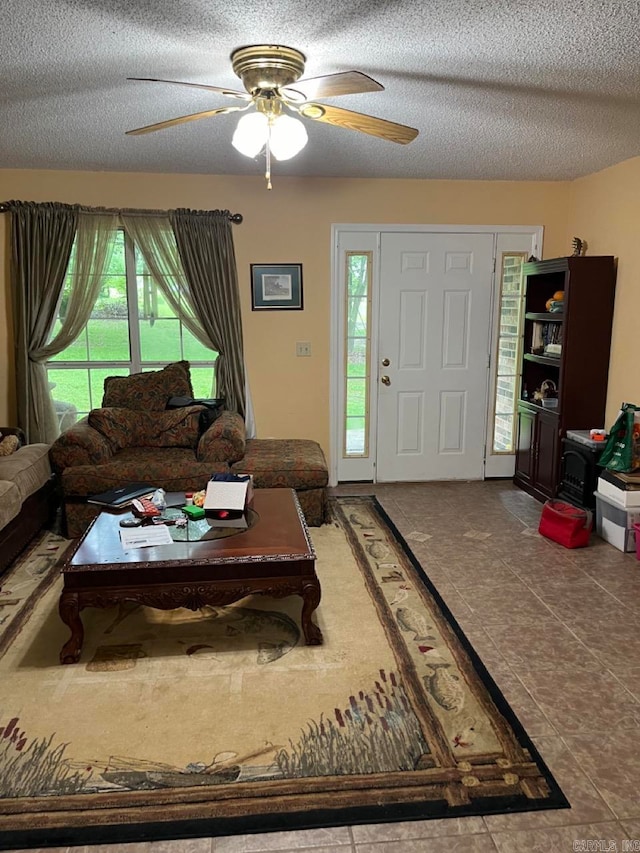 tiled living room featuring a textured ceiling and ceiling fan