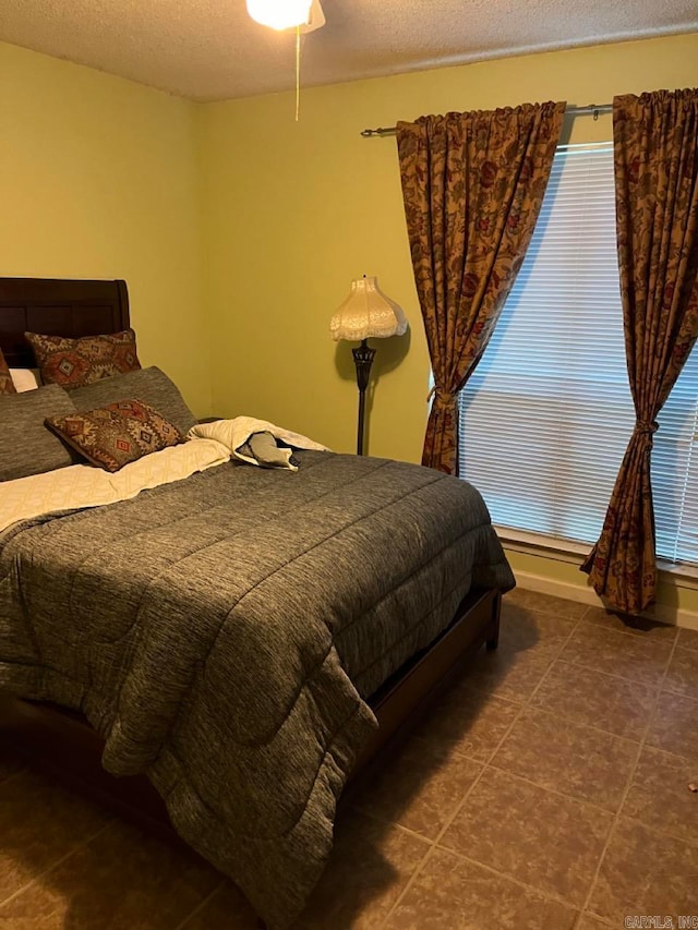 bedroom featuring a textured ceiling and dark tile patterned flooring