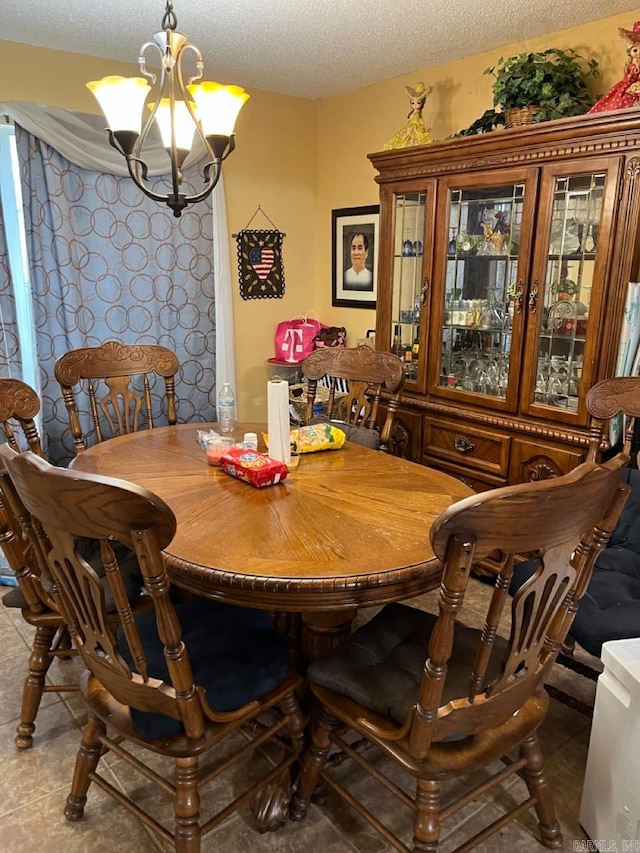 dining area with a notable chandelier and a textured ceiling