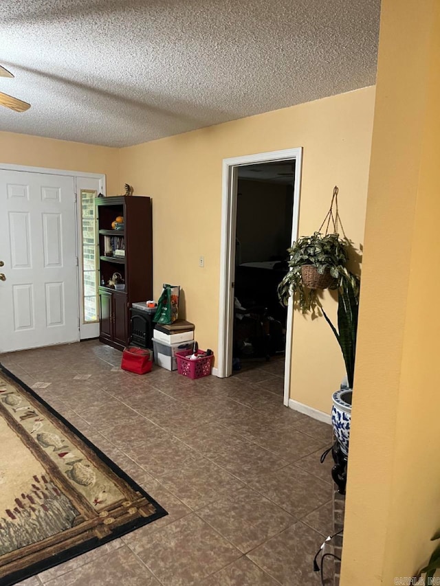 interior space featuring a textured ceiling and ceiling fan