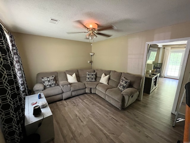 living room featuring a textured ceiling, ceiling fan, and hardwood / wood-style floors